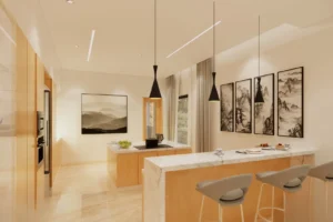 Modern kitchen with light wood cabinetry and marble countertops, featuring a central island with stove, three contemporary gray bar stools, black pendant lights hanging from the ceiling, and framed mountain landscape artwork on the walls under soft, warm lighting.
